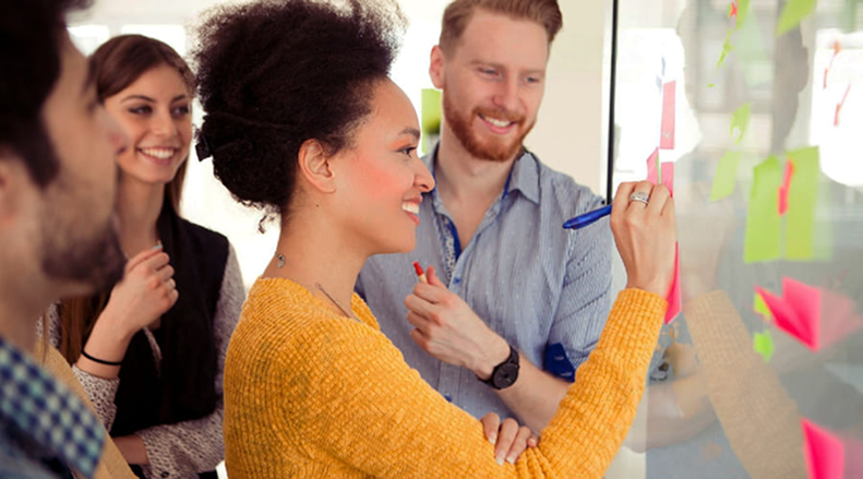 Team collaborating around a glass board